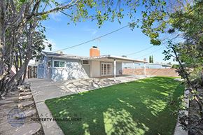 Granada Hills apartment for rent - A house with a well-maintained lawn and trees in the foreground.