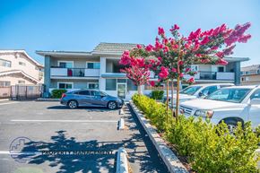 Downey apartment for rent - a parking lot with cars in front of an apartment building