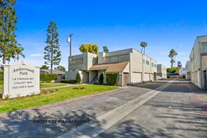 Anaheim apartment for rent - A sign for Amberwood Park is in front of some buildings.