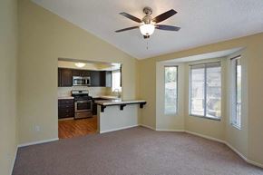 La Habra apartment for rent - an empty living room with a kitchen and a ceiling fan