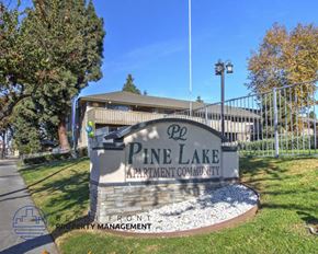 Garden Grove apartment for rent - A sign for Pine Lake Apartment Community is displayed in front of a building.