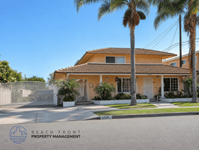 Downey apartment for rent - A house with a fence and palm trees in front of it.