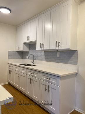 Buena Park apartment for rent - A kitchen with white cabinets and a marble countertop.