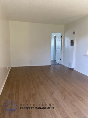 Buena Park apartment for rent - the living room of an empty apartment with wood flooring
