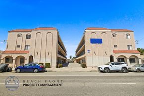 Torrance apartment for rent - Two buildings with cars parked in front and a sign that says "Beach Front Property Management".