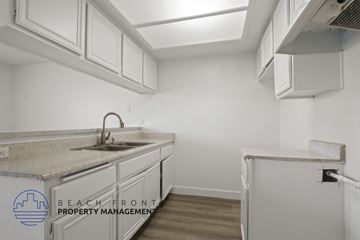 Torrance apartment for rent - A kitchen with white cabinets and a marble countertop.