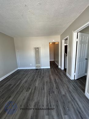 Long Beach apartment for rent - an empty living room with wood flooring and white walls