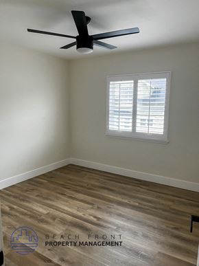 Hermosa Beach apartment for rent - A room with a ceiling fan and wooden flooring.