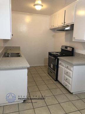 Whittier apartment for rent - a kitchen with white cabinets and a stove and a sink