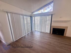 Los Angeles apartment for rent - A room with a fireplace and a large window with blinds.