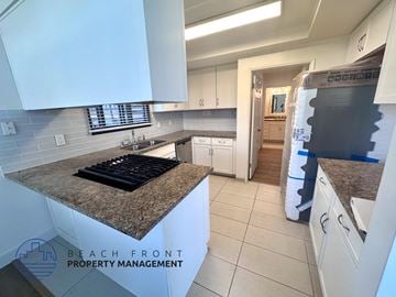Los Angeles apartment for rent - A kitchen with granite countertops and white cabinets is for sale.
