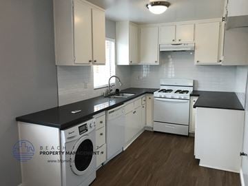 Los Angeles apartment for rent - a white kitchen with white appliances and black counter tops