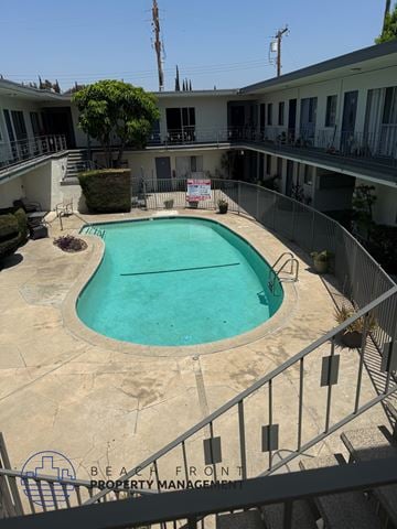 Inglewood apartment for rent - A pool surrounded by a fence and a sign that says "Property Management".