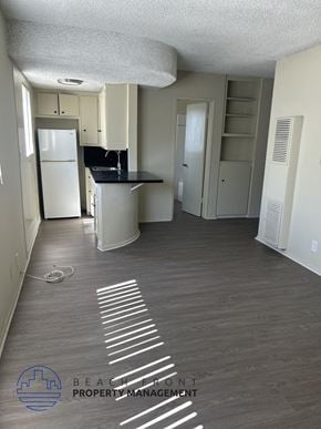 Los Angeles apartment for rent - A kitchen area with a refrigerator, sink, and cabinets.