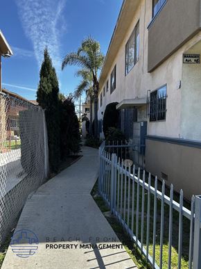 Los Angeles apartment for rent - A white fence runs along the side of a building.