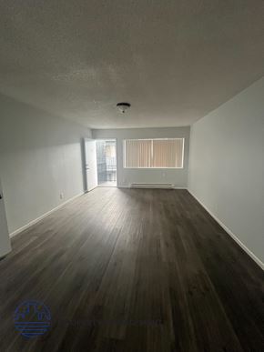 Long Beach apartment for rent - A room with wooden floors and white walls.