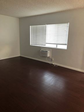 Whittier apartment for rent - an empty living room with wood floors and a window