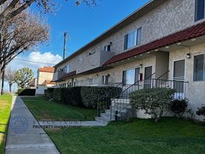 Torrance apartment for rent - a view of the side of an apartment building with a sidewalk and grass
