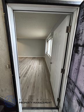 Los Angeles apartment for rent - A doorway opens to a hallway with wooden floors and white walls.