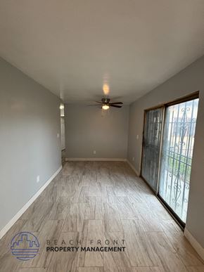 Los Angeles apartment for rent - A spacious room with a ceiling fan and sliding glass doors.