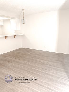 Torrance apartment for rent - A room with a wooden floor and a hanging light fixture.