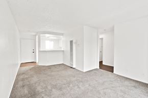 Long Beach apartment for rent - A spacious, empty room with carpeted floor and white walls.