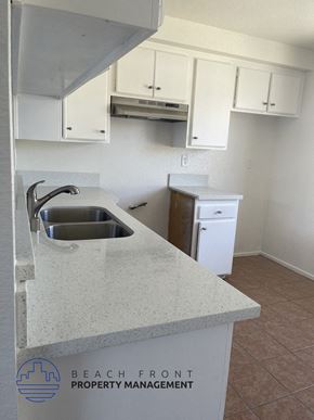 Hawthorne apartment for rent - an empty kitchen with white cabinets and a sink