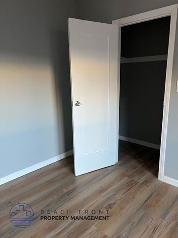 Los Angeles apartment for rent - A white door is open in a room with wooden flooring.