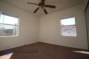 San Pedro apartment for rent - A room with a ceiling fan and two windows.