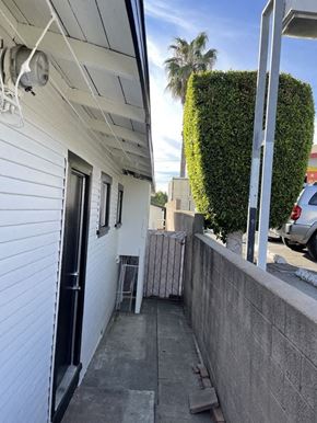 San Pedro apartment for rent - the front door of a white house with a sidewalk and a gate