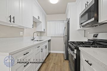 Playa Del Rey apartment for rent - A kitchen with white cabinets and a black stove top oven.