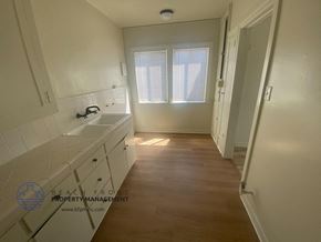San Pedro apartment for rent - A white bathroom with a sink, mirror, and wooden floor.