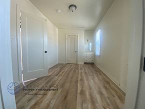 San Pedro apartment for rent - A hallway with wooden floors and white walls.