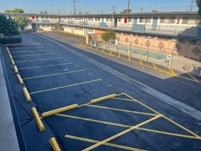 Gardena apartment for rent - A parking lot with yellow lines and a pool in the background.