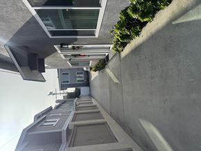 Redondo Beach apartment for rent - A modern building with a grey exterior and a green plant on the top.