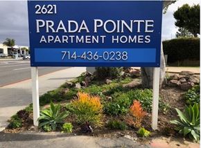 Costa Mesa apartment for rent - A blue sign for Prada Pointe Apartment Homes with a phone number on it.