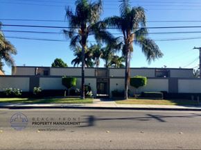 Lynwood apartment for rent - A building with palm trees in front and a sign for Beach Front Property Management.