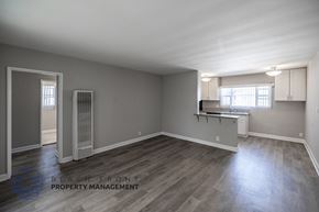 Long Beach apartment for rent - A spacious room with wooden flooring and a window with blinds.