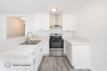 Orange apartment for rent - A modern kitchen with white cabinets and stainless steel appliances.