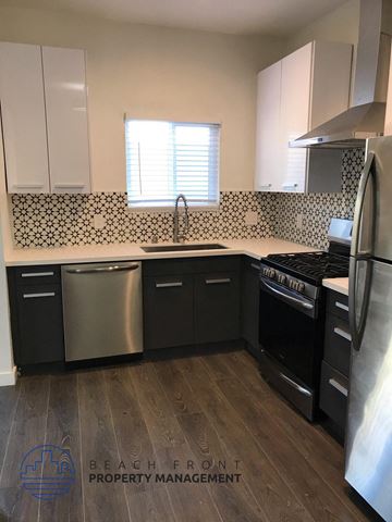 Los Angeles apartment for rent - a kitchen with black cabinets and a stove and a sink