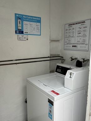 Gardena apartment for rent - A washing machine with a sign that says "No Coins Needed" on the wall behind it.