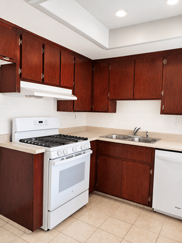 Huntington Beach apartment for rent - A kitchen with white appliances and brown cabinets.