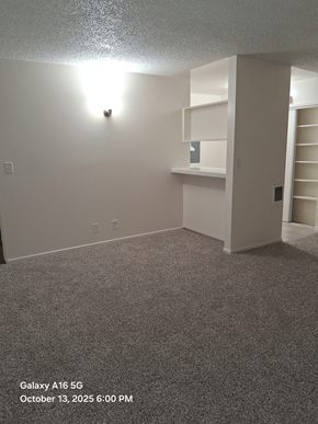 Lawndale apartment for rent - A room with a carpeted floor and a wall-mounted shelf.