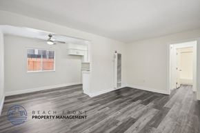 Whittier apartment for rent - the living room and kitchen of an apartment with wood flooring and a ceiling fan