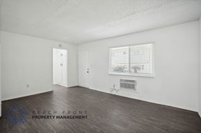 Whittier apartment for rent - a bedroom with white walls and wood floors and a window