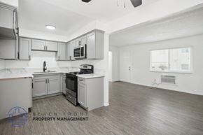 Whittier apartment for rent - a kitchen with white and gray cabinets and a stove top oven