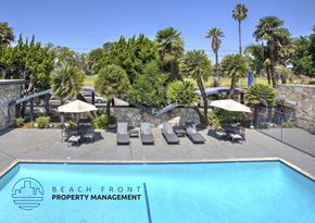 Downey apartment for rent - A pool surrounded by palm trees and lounge chairs with the words