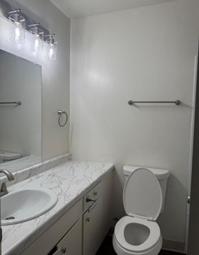 Torrance apartment for rent - A white toilet in a small bathroom with a marble counter top.