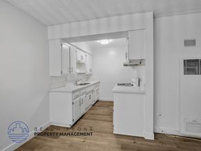 Inglewood apartment for rent - A kitchen with white cabinets and a wooden floor.