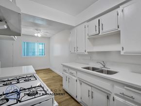 Inglewood apartment for rent - A modern kitchen with white cabinets and a stove top.